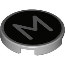 Part 14769pb434 - Tile, Round 2 x 2 with Bottom Stud Holder with Silver Capital Letter M on Black Background Pattern